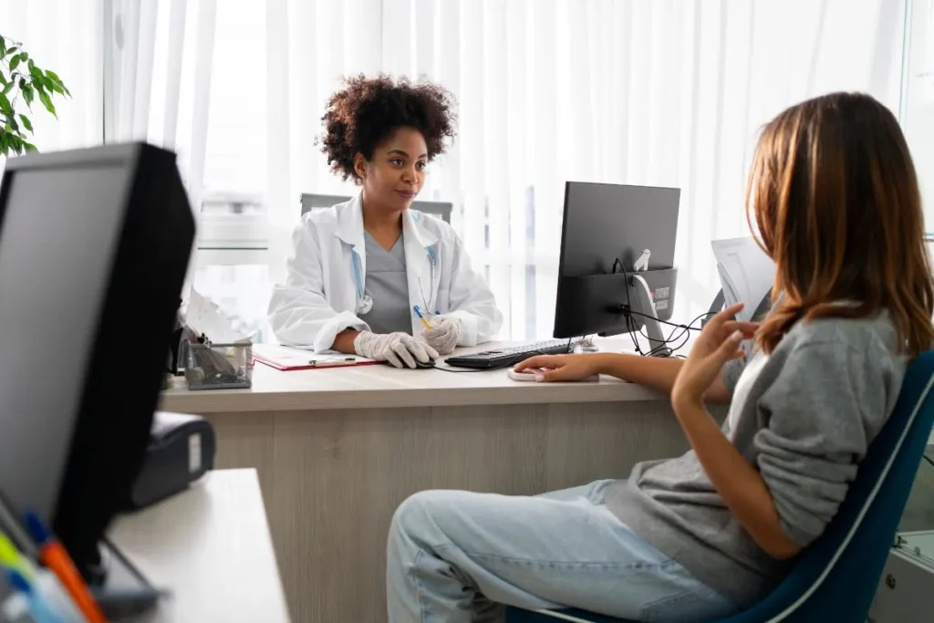 Profissional de saúde conversando com paciente durante coleta da HDA na anamnese