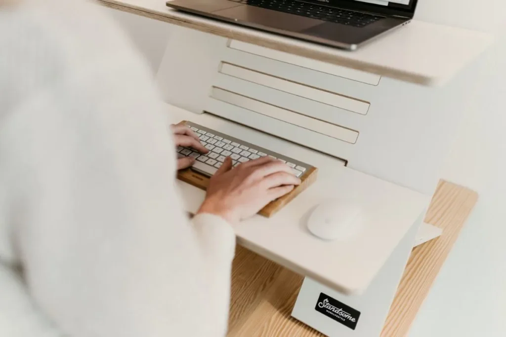 Profissional digitando em teclado para consultar código TUSS colonoscopia em sistema online.