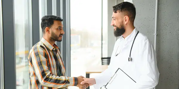 médico com a porta aberta chamando um paciente