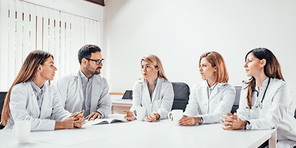 medicos-conversando-ao-redor-de-uma-mesa