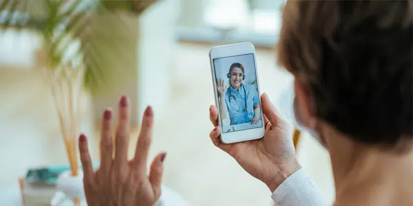 Profissional de saúde atendendo paciente via telemedicina.