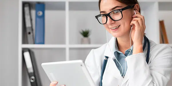 Médica segurando tablet, atendendo por teleconsulta