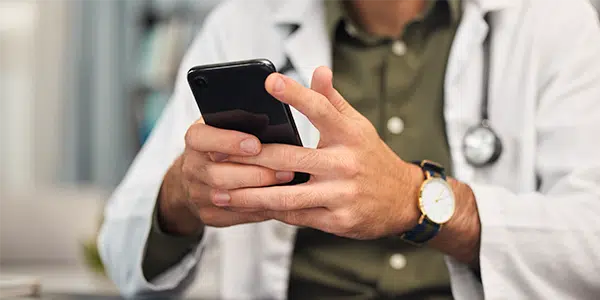 Médico mexendo no celular