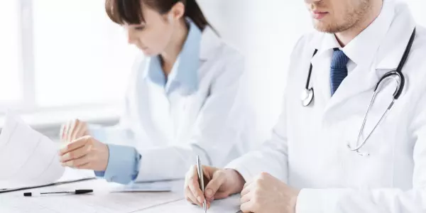 médicos assinam documentos