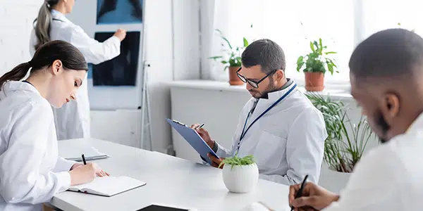 Quatro profissionais da saúde em sala de reuniões