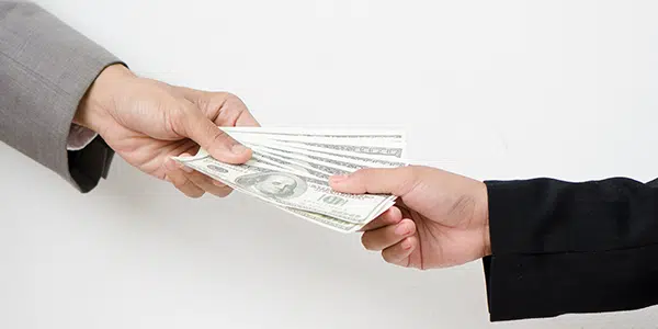 Mãos seguram bolo de dinheiro