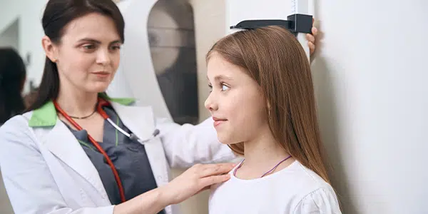Pediatra mede altura de menina