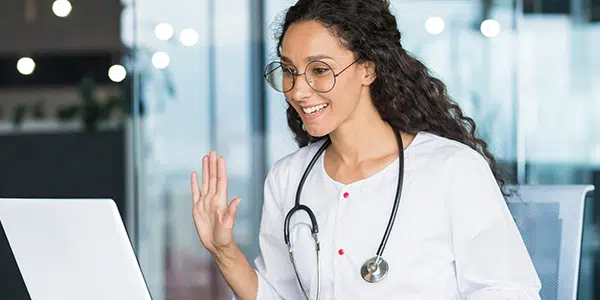 Médica atendendo paciente remotamente por telemedicina