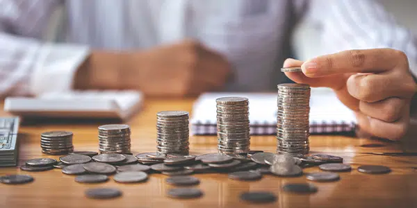 Homem contando pilhas de moedas