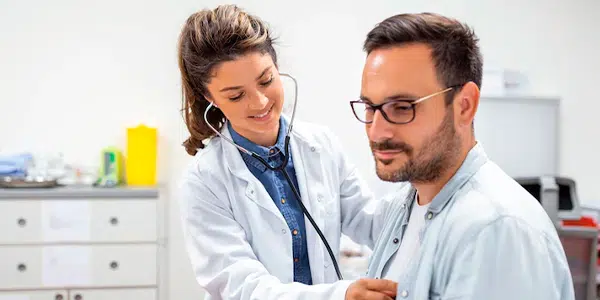 Médica auscultando paciente em consulta