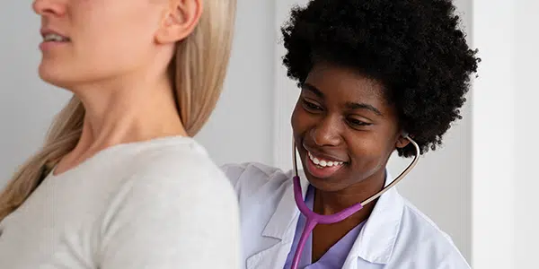 Médica auscultando paciente com estetoscópio