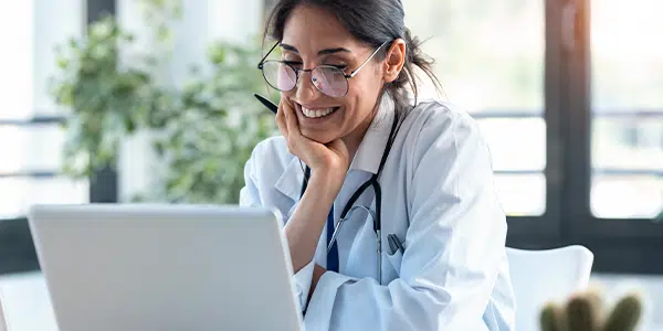 Médica sorrindo para computador