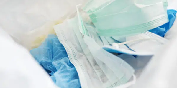 Máscaras descartáveis em lixo hospitalar