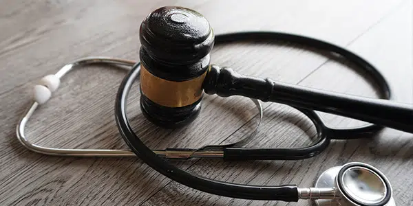 Martelo de juiz e estetoscópio sobre a mesa