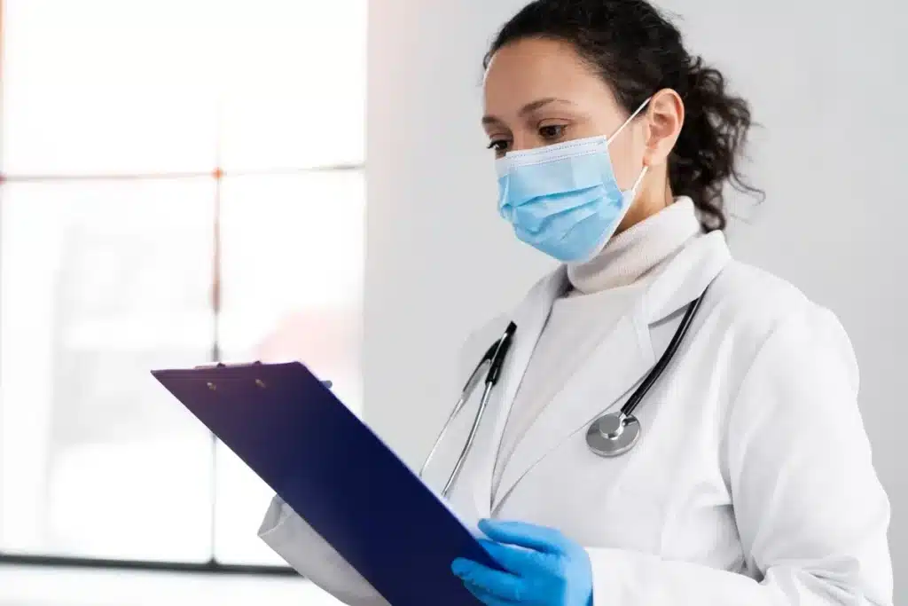 Médica de máscara com prancheta em prática médica